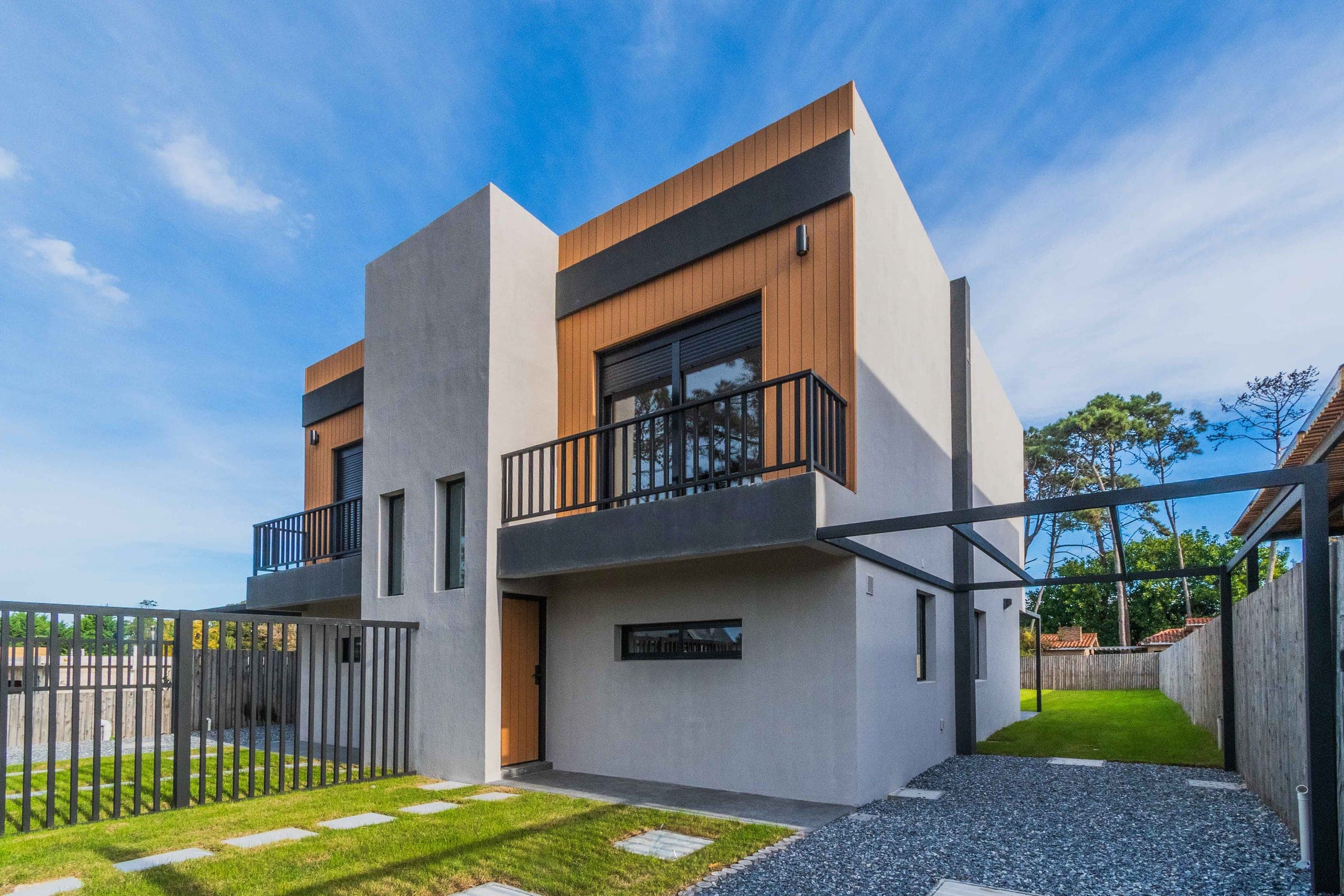 Fachada de las casas dúplex de Médanos II, con revestimiento de madera
